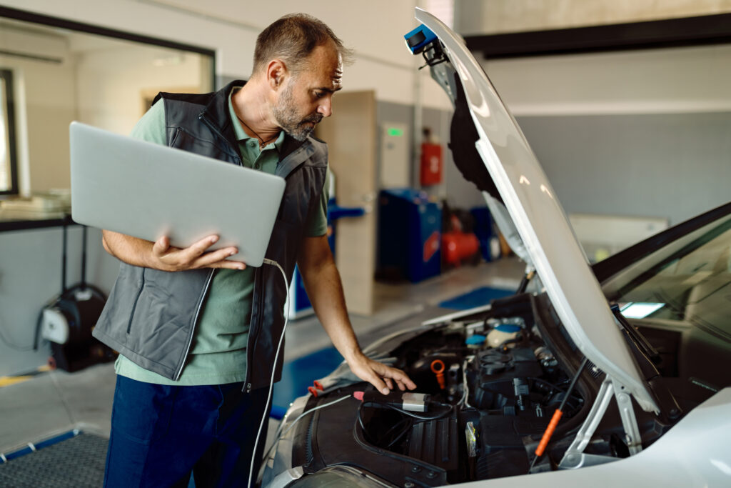 auto-repairman-using-laptop-while-examining-car-engine-in-a-work-1024x683